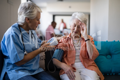 Senior woman complaining about headache to doctor