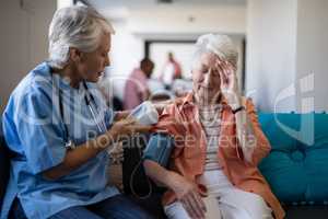 Senior woman complaining about headache to doctor