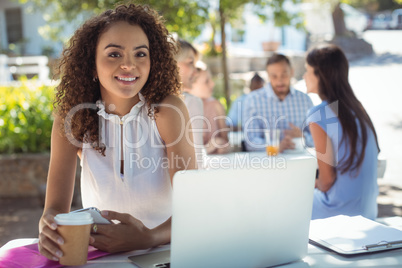 Beautiful woman holding coffee cup and mobile phone