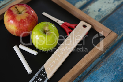 School supplies and slate on wooden table