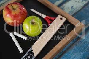 School supplies and slate on wooden table