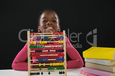 Cute girl with abacus against black background