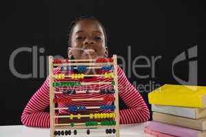 Cute girl with abacus against black background
