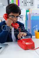 Boy imitating as businessman using land line phone