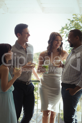 Group of friends interacting with each other while having cocktail drink