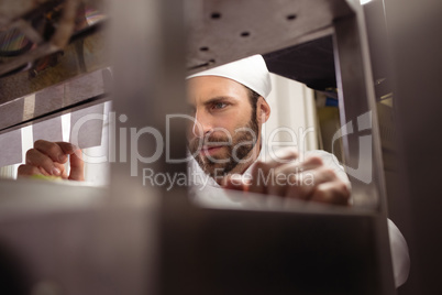 Chef reading his order on sticky note in kitchen counter