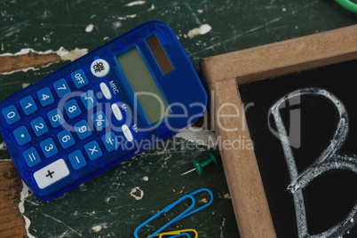 Calculator and chalkboard on table