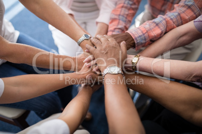 Cropped image of senior people and female doctor stacking hands