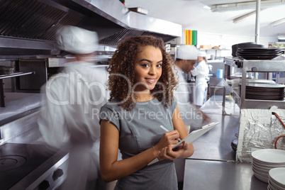 Manager writing on clipboard in commercial restaurant