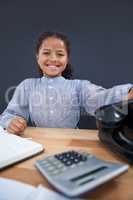 Portrait of smiling girl holding landline phone