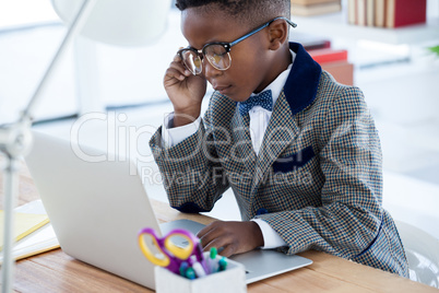 Businessman wearing eyeglasses while using laptop