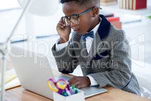 Businessman wearing eyeglasses while using laptop