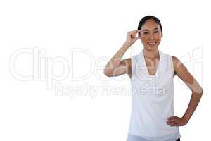 Portrait of smiling woman with hand on hip adjusting invisible eyeglasses