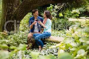 Romantic couple toasting a glass of red wine in garden