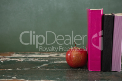 Apple and books on table