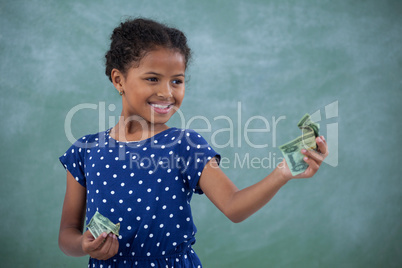 Smiling girl looking at paper currency