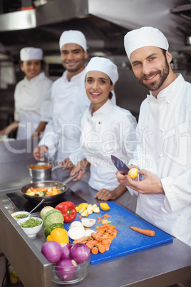 Chefs chopping vegetables on chopping board in the commercial kitchen