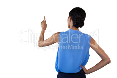 Rear view of businesswoman with hand on hip touching interface