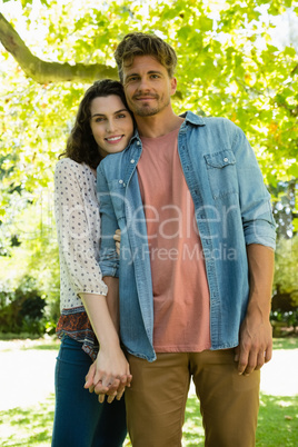 Romantic couple holding hands in garden