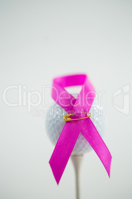Close-up of pink Breast Cancer Awareness ribbon on golf ball