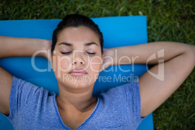 Trainer with closed eyes resting on exercise mat