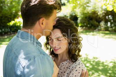 Man kissing woman on forehead