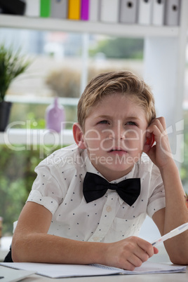 Businessman thinking while making report at desk