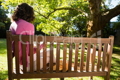 Woman sitting on bench and reading book