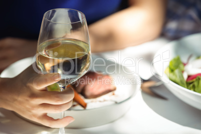 Woman holding glass of wine in restaurant