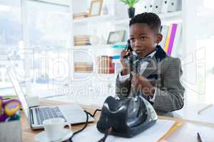 Businessman looking away while talking on telephone