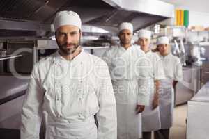 Happy chefs team standing together in commercial kitchen