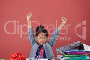 Portrait of businesswoman stretching while sitting at desk