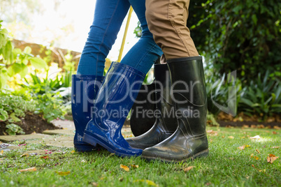 Couple standing with gardening rake and shovel in garden