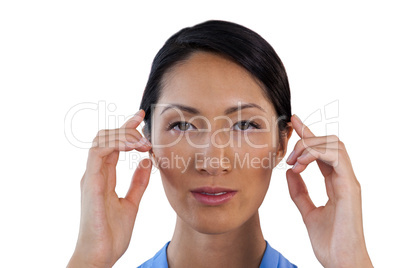 Close up portrait of businesswoman adjusting invisible eyeglasses