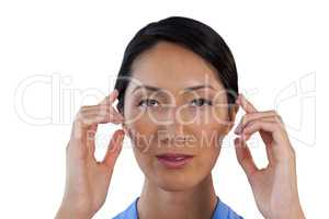 Close up portrait of businesswoman adjusting invisible eyeglasses