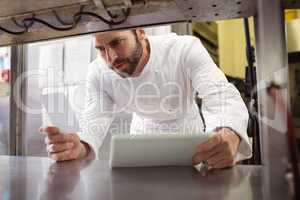 Chef reading his order on sticky note in kitchen counter