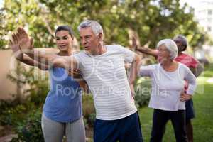 Trainer showing stretching exercise to senior people
