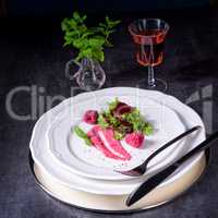 Carpaccio of baked red pray with green salad and raspberry