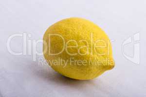 A yellow lemon on a white surface