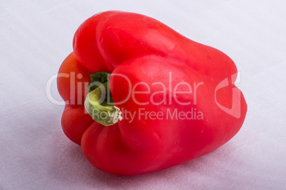 A red pepper on a white surface