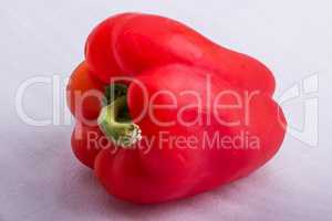 A red pepper on a white surface