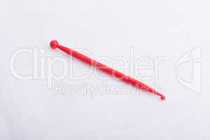 A red plastic sculpting tool on a white surface