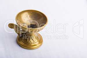 A bronze incense burner on a white surface