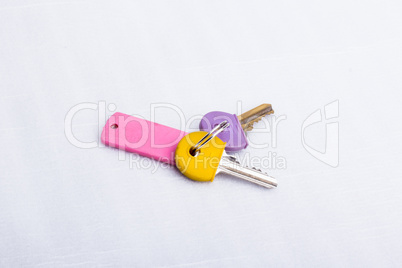 A set of two keys, on a key ring, on a white surface