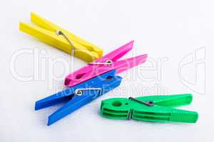 Four colorful clothespins on a white surface