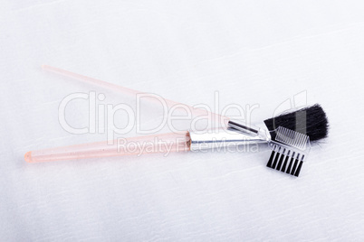 A brush and a double sided eyelash & eyebrow comb, on a white su