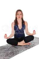 Woman sitting on floor in yoga position.