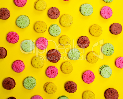 Colorful pastry macaroons on a yellow background