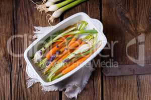 Young carrots and spring onions prepared for baking