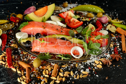 Fillet of salmon and spices on a dark background